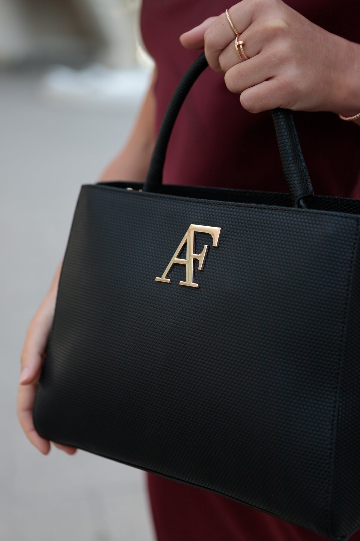 Navona, top-handle bag in black honeycomb-embossed Italian leather – carried by hand