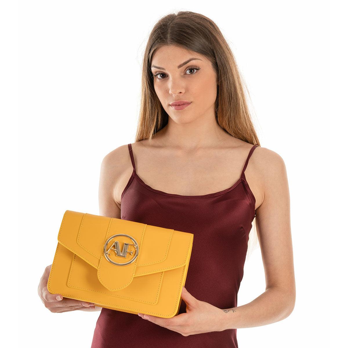 Brera, crossbody bag in yellow smooth Italian Ruga leather – held in both hands as a clutch