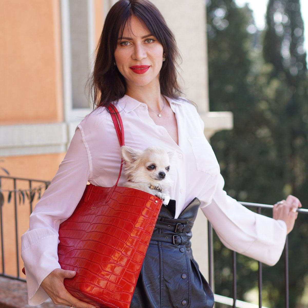 Woman on a Florence terrace holding a red croc-embossed Italian leather tote, the croc trend for autumn 2026