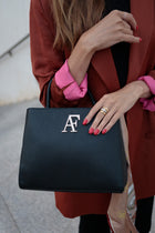 Navona, top-handle bag in black textured Italian leather – carried by hand