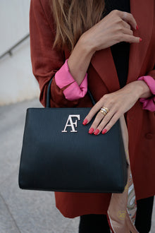 Navona, top-handle bag in black textured Italian leather – carried by hand