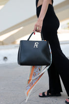 Navona, top-handle bag in smooth black Italian leather – carried by hand