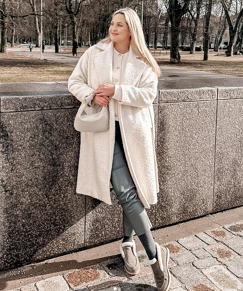 Woman in a white coat with a white Italian leather shoulder bag