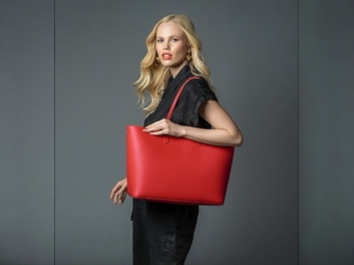 Model carrying a red smooth Italian leather tote bag