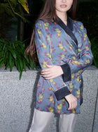 Ornella, wrap blouse in grey-blue hummingbird-print 100% Mulberry silk – on model 2 – Alinari Firenze