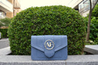 Brera, crossbody bag in blue smooth Italian Ruga leather – front view outdoors in daylight