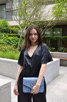 Brera, crossbody bag in blue smooth Italian Ruga leather – carried by hand, styled with the Vittoria Silk Jumpsuit