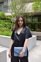 Vittoria, jumpsuit in black 100% Mulberry silk – on model, styled with the Brera crossbody bag in blue Italian leather – Alinari Firenze