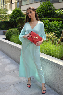 Isabella, jurk met kimonomouwen van aquamarijn 100% moerbeizijde – gedragen, gecombineerd met de Brera crossbodytas van rood Italiaans leer – Alinari Firenze