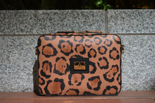 Flavia, crossbody bag in leopard-print Italian Ruga leather – front view outdoors, showing the print and logo plate