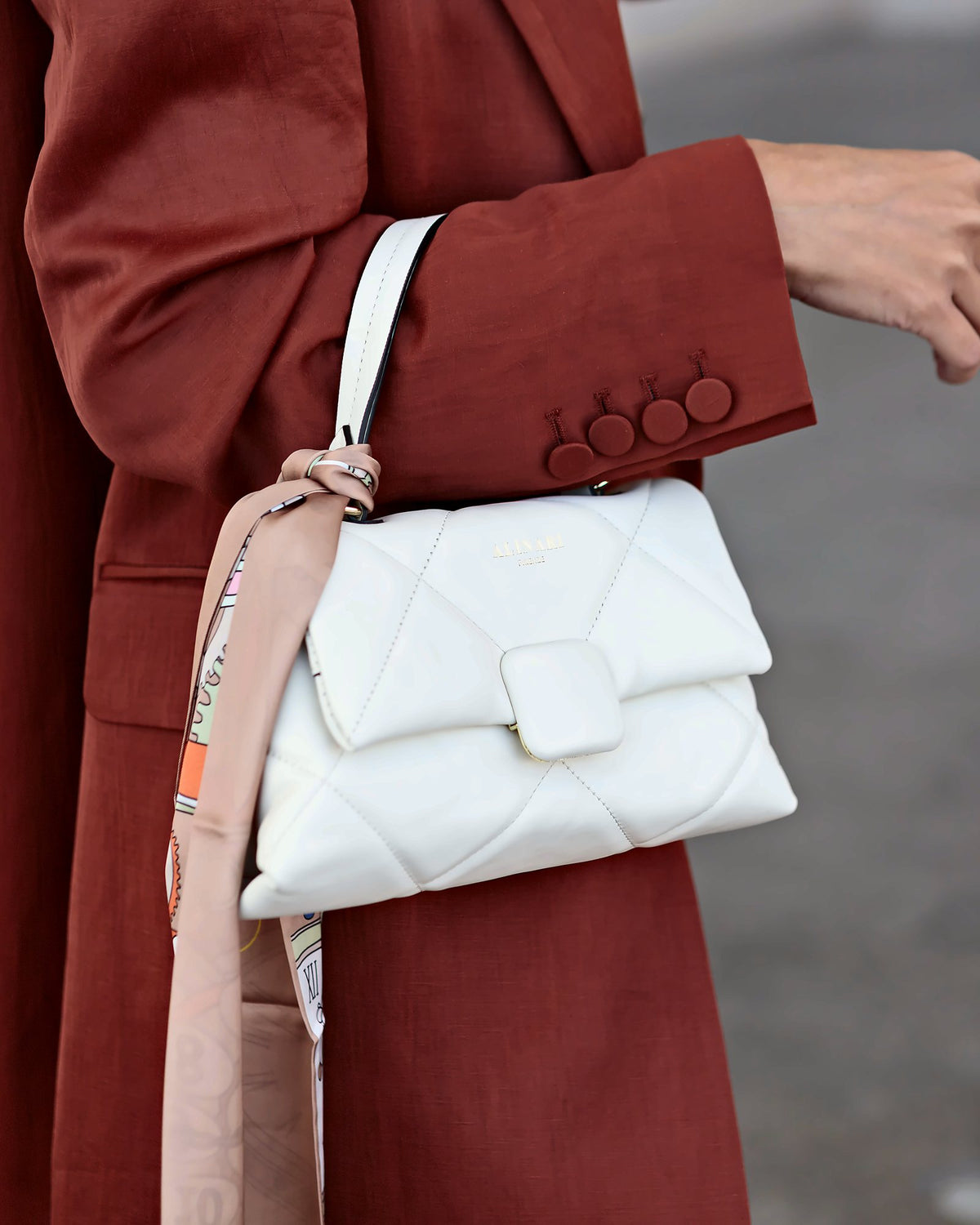 Alita, shoulder bag in white quilted Italian leather – carried on the arm with a rust linen blazer and a silk twilly