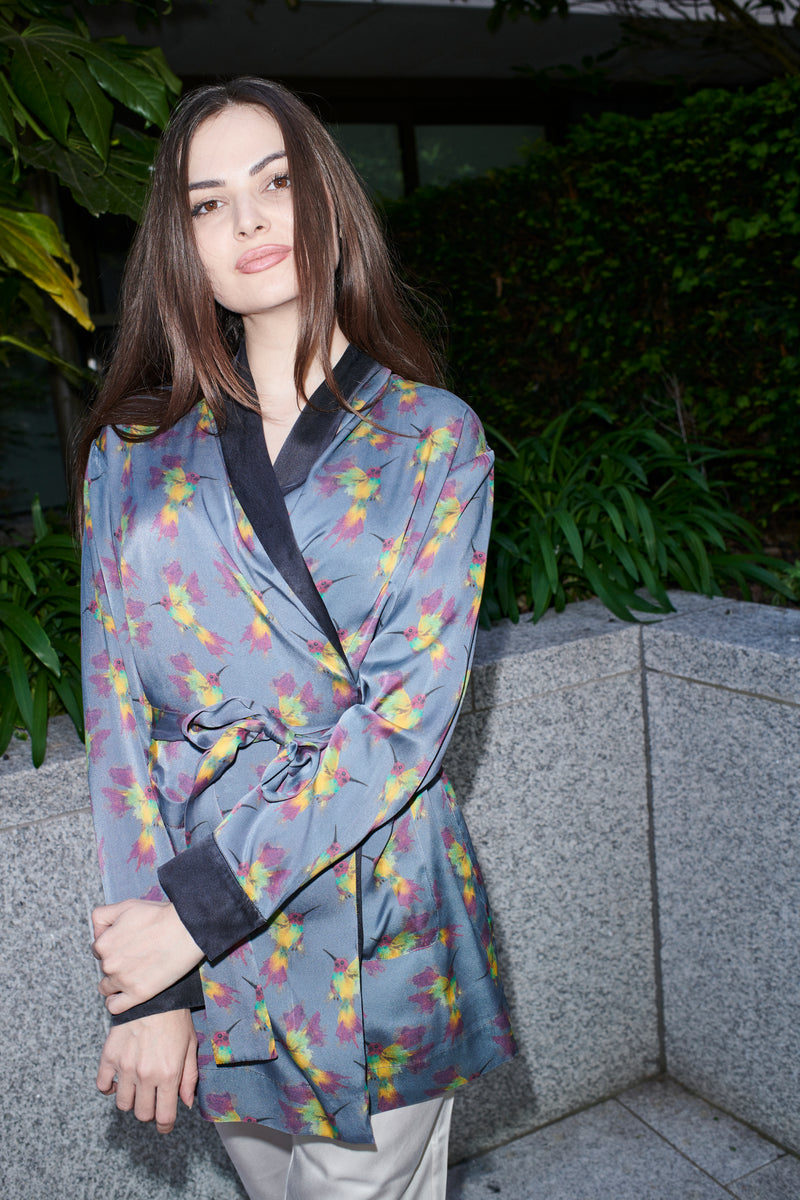 Ornella, wrap blouse in grey-blue hummingbird-print 100% Mulberry silk – on model – Alinari Firenze
