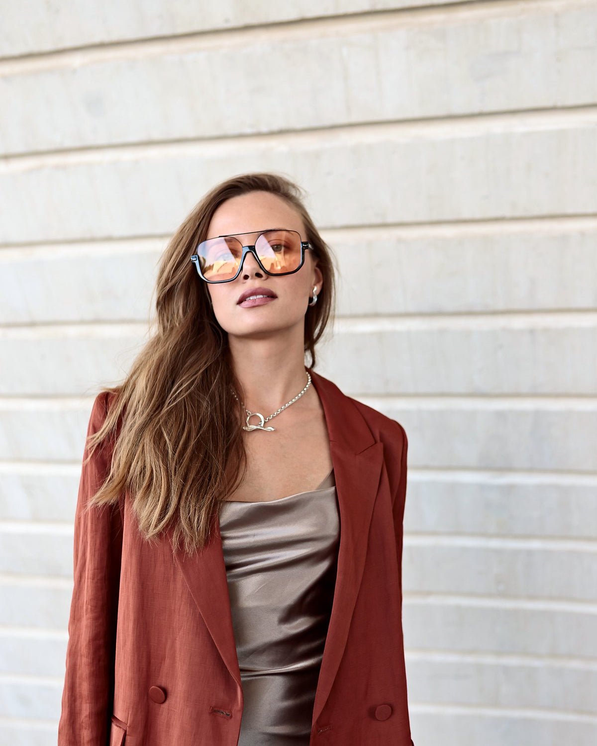 Toscana, sunglasses in black with rose-tint lenses – worn with a rust linen blazer over a champagne satin dress